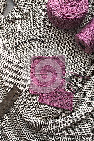 Lilac knitting yarn with scissor, kneeting needles and glasses on vintage blanket background Stock Photo