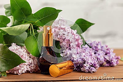 Lilac perfume - scent sprayer and blossoms on wooden table Stock Photo