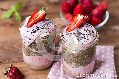 Lilac smoothie with strawberry, baÑ‚anas and chia pudding in two jars on wooden background Stock Photo