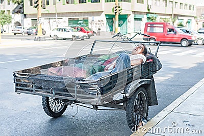 LIMA, PERU - APRIL 15, 2013: Peruvian male is sleeping in Motorcycle in Lima, Peru. Editorial Stock Photo