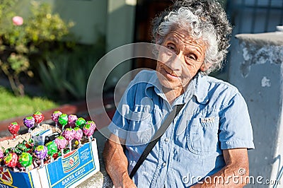LIMA, PERU - APRIL 12, 2013: An unidentified Peruvian woman selling Chupa Chups sweets on the street. Closeup face Editorial Stock Photo