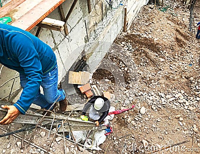 Builders climbing on ladder in construction site. Cement and rocks. Editorial Stock Photo