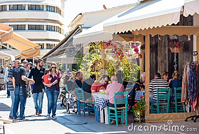 LIMASSOL, CYPRUS - APRIL 1, 2016: Street cafe with people passing by in old part of the city Editorial Stock Photo