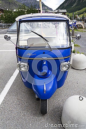 Limited edition model of three-wheeled vehicle Piaggio Ape Calessino stands on street on 1 August 2016 in Livigno, Italy. Editorial Stock Photo