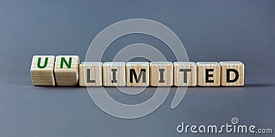 Limited or unlimited symbol. Turned wooden cubes and changed words `limited` to `unlimited`. Grey background, copy space. Busi Stock Photo