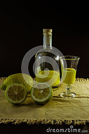 Limoncello traditional italian lemon liqueur with bottle, glass and fresh lemon halves Stock Photo