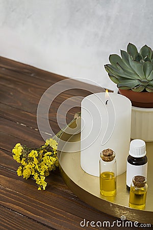 limonium flower with white large lighted candle essential oil bottle wooden desk. High quality photo Stock Photo