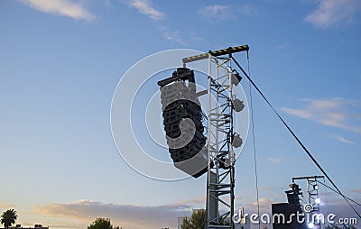 Line array speaker system hanging from pole during daylight performance Stock Photo