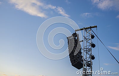 Line array speaker system hanging from pole during daylight performance Stock Photo