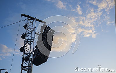 Line array speaker system hanging from pole during daylight performance Stock Photo