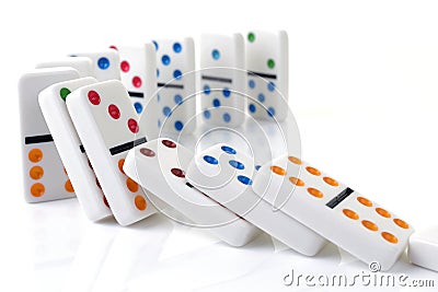 Falling colorful dominoes on a white surface Stock Photo