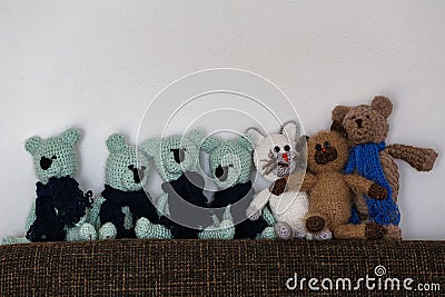 Line of homemade knitted toys on a sofa Stock Photo