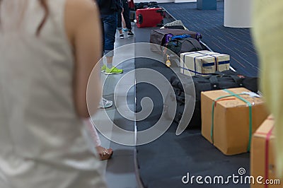 Line of luggage and belonging and people waiting for claim on ar Stock Photo