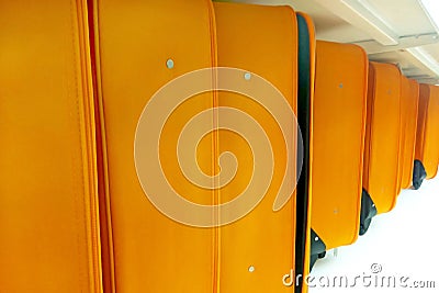 Line of many orange luggage bags and suitcases on the shelf conveyor Stock Photo