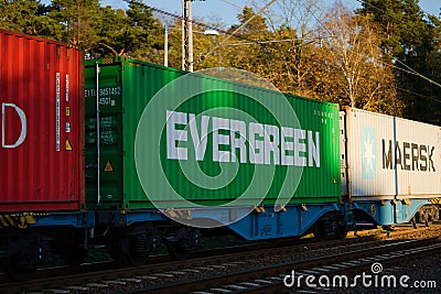 Line of train carriages with red, green and beige containers Editorial Stock Photo