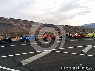 Line of two-seat scooter cars in parking lot with mountain landscape Editorial Stock Photo