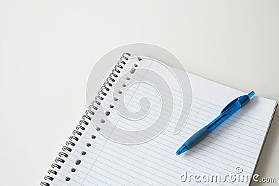 Lined paper with blue pen on white desk. Space for text. Stock Photo