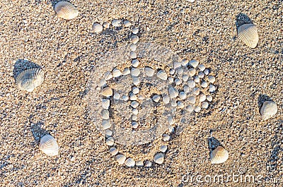 Lined with seashells glass with a cocktail in the sand Stock Photo