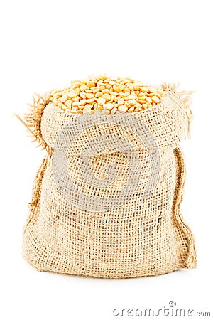 A linen sack filled by the crushed dry yellow peas Stock Photo