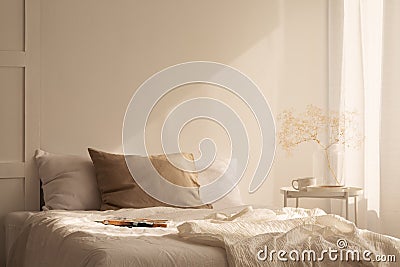 Linen sheets ion king size bed in minimal bedroom with empty wall Stock Photo