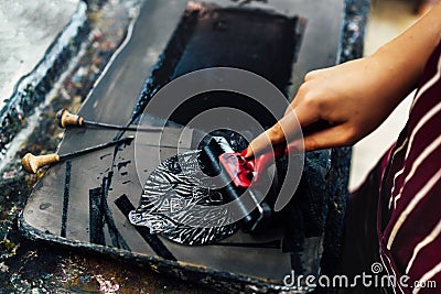 Linocut. rolling paint on a piece of linoleum Stock Photo