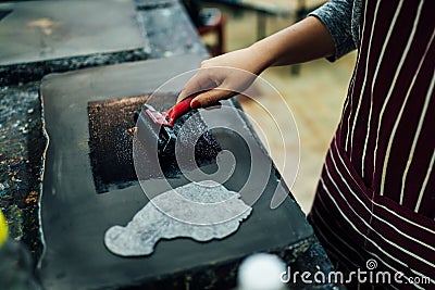 Linocut. rolling paint on a piece of linoleum Stock Photo