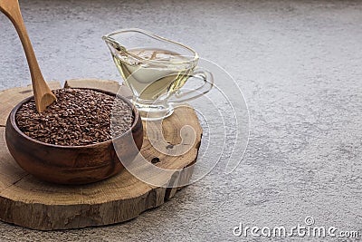 Linseed oil in a glass gravy boat and flaxseed in a wooden bowl vegetable source of omega-3, lowers cholesterol, used in food as a Stock Photo