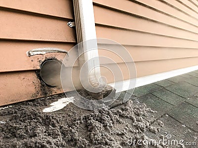 Lint collected from dryer machine is bloving out from vent Stock Photo