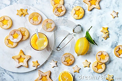 Linzer Christmas cookies filled with lemon curd and dusted with sugar on white marble board. Stock Photo