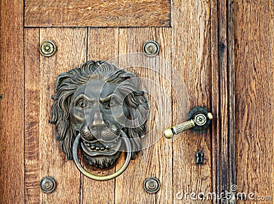 Lion knocker and handle on wooden door Stock Photo