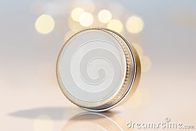 Lip balm in metal jar over light bokeh background Stock Photo