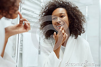 Lips skin care. Woman applying lip balm in bathroom portrait Stock Photo