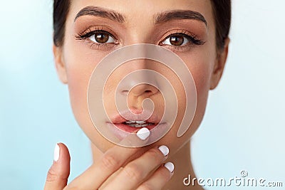 Lips Skin Care. Woman With Beauty Face Applying Lip Balm On Stock Photo
