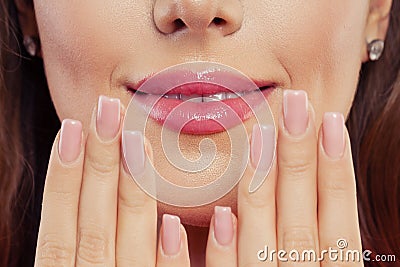 Lips with trendy color glossy lipgloss makeup. Beautiful female mouth and perfect manicured nails Stock Photo