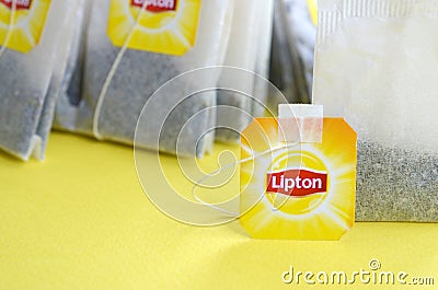 Lipton Yellow Label black tea bags on pastel yellow surface close up. Lipton is a world famous brand of tea Editorial Stock Photo