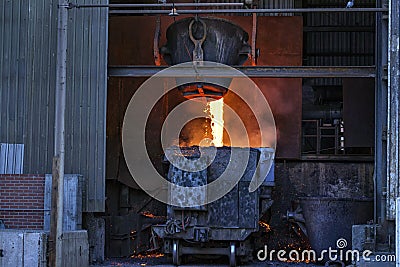 Liquid copper slag is pouring from melting pot to carriage in the copper mining factory Stock Photo