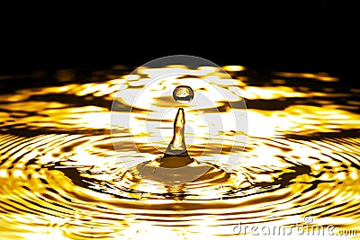 Liquid gold drop and ripple Stock Photo