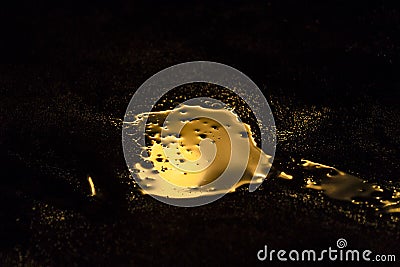 Liquid gold is spilled in a dark room Stock Photo