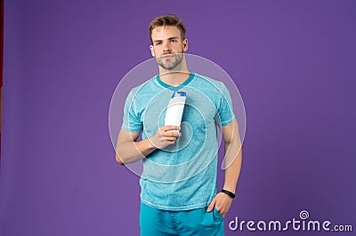 Liquid soap. Cherishing my skin. Man cheerful handsome sportsman hold bottle shampoo shower gel. Shampoo conditioner for Stock Photo