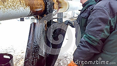 Liquidation of the oil spill. Locksmiths are engaged in eliminating oil leakage and repairing equipment. Workers liquidate the oil Editorial Stock Photo