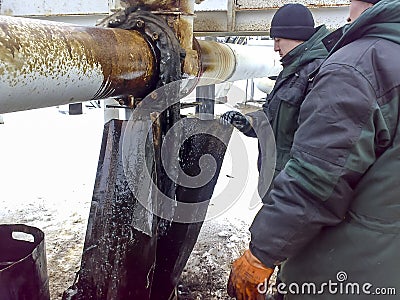 Liquidation of the oil spill. Locksmiths are engaged in eliminating oil leakage and repairing equipment. Workers liquidate the oil Editorial Stock Photo