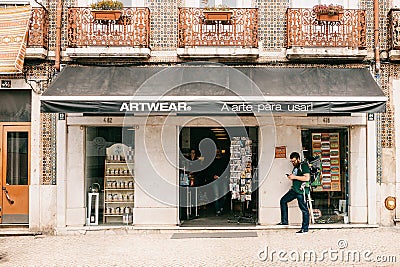 Lisbon, June 18, 2018: Authentic store of art clothes and souvenirs. People inside the store. Nearby on the street there Editorial Stock Photo