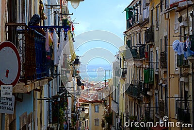 Lisbon narrow alley with old residential buildings and drying cloths Editorial Stock Photo