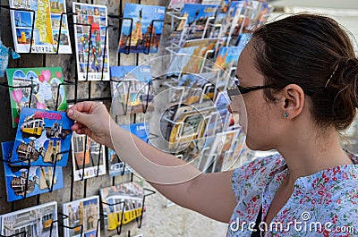 Lisbon, Portugal - 22 august 2018: Girl looking at colorful postcards in Lisbon Editorial Stock Photo