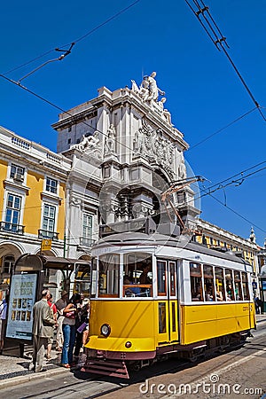 Lisbon, Portugal: Carris vintage yellow tram and Rua Augusta Street Triumphal Arch in Praca do Comercio aka Co Editorial Stock Photo