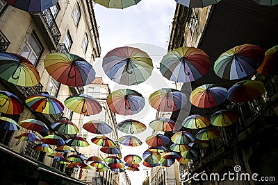 Multicolored umbrellas hanging on the Pink street in Lisbon Editorial Stock Photo