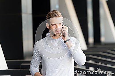 Listen to me. Man beard walks with smartphone, urban background. Man with beard serious face talk smartphone. Guy Stock Photo