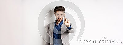 Listen to me. Serious male ceo manager showing one finger, scolding or telling to stop, tell no, hold right there sign Stock Photo