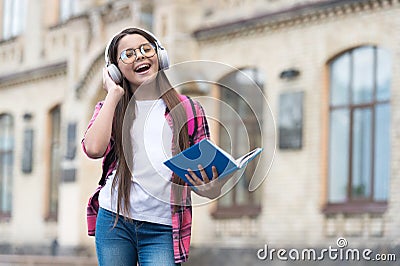 Listen up. Happy child hold book listening to earphones. English school. Distance education. Foreign language. Audio Stock Photo