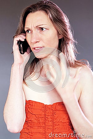 worried woman on cell phone beautiful young classy in cocktail dress Stock Photo
